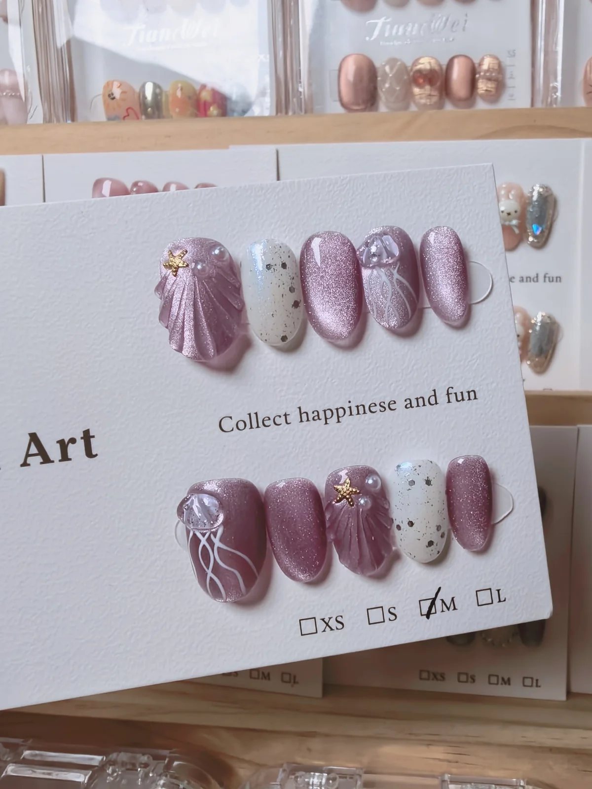 Handmade pink shimmer press-on nails with shell, starfish, pearls and silver line art