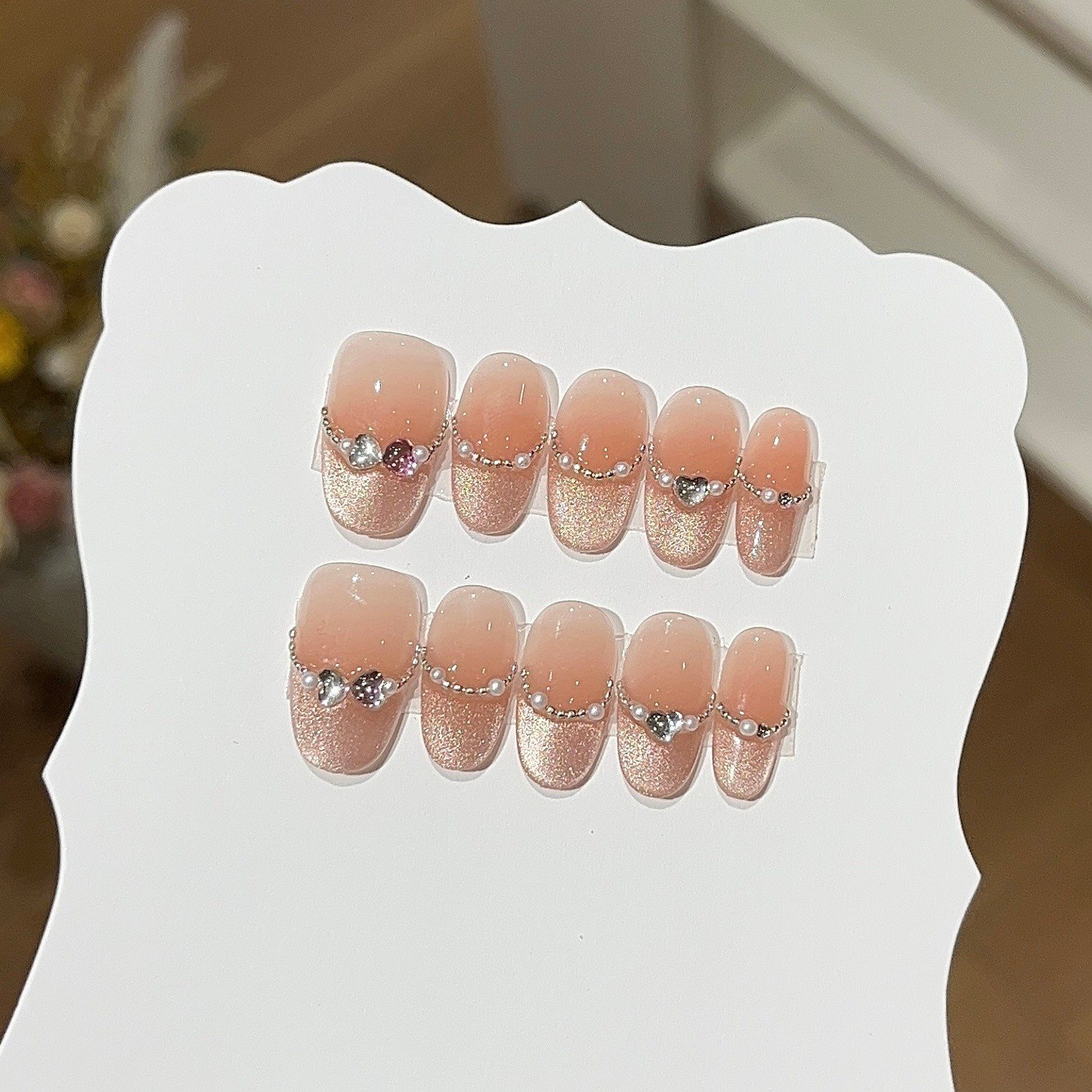 Handmade nude square press-on nails with crystal hearts, pearls and glitter French tips