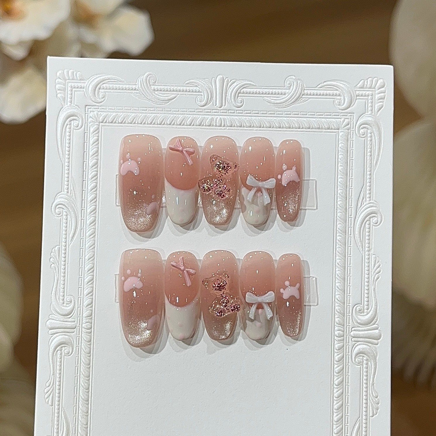 Handmade pink press-on nails with bow, bunny, glitter and white frame display